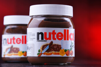 Two jars of Nutella hazelnut spread on a red background