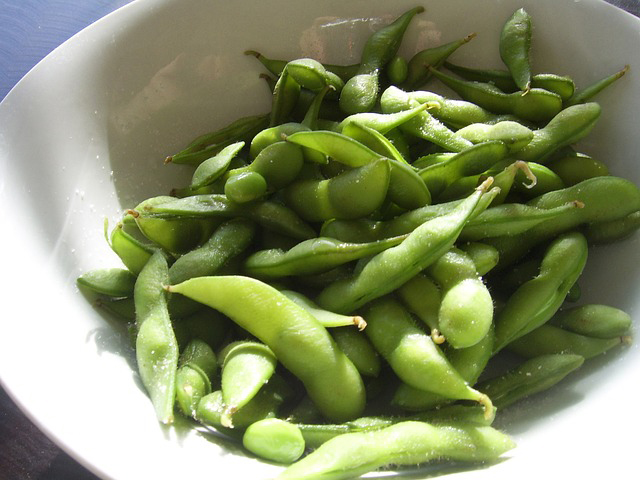 Fresh edamame in a white bowl.