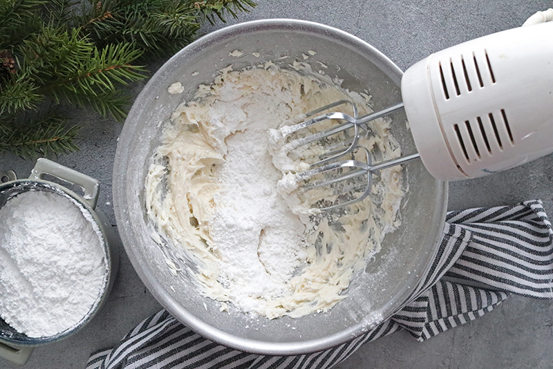 mixing icing ingredients with an electric hand mixer