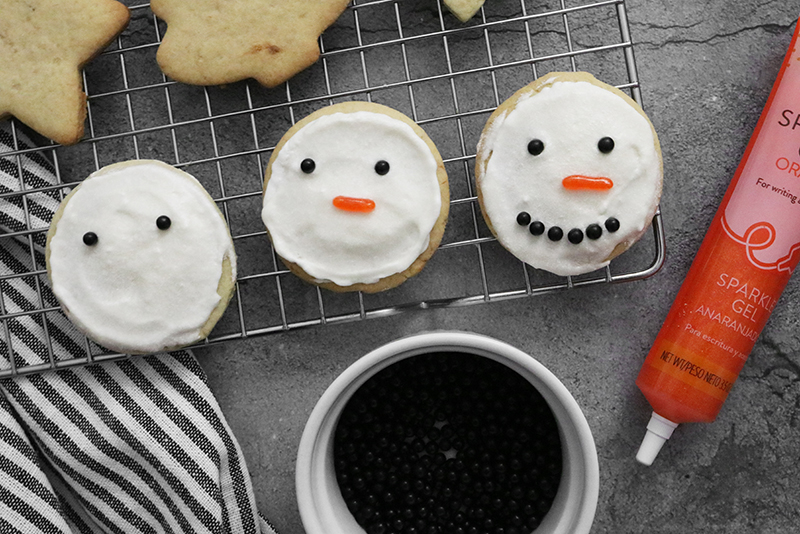 Vegan Sugar Cookies cooling on a wire rack with snowman faces