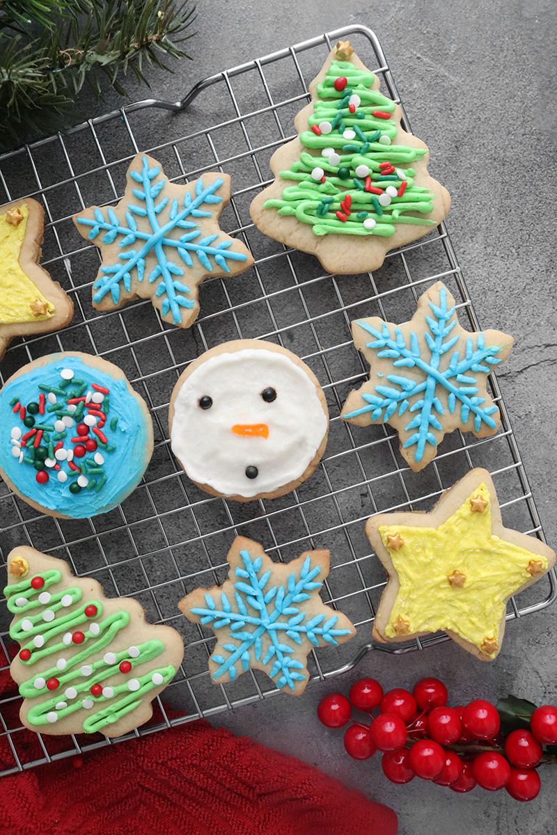 Assorted designs of Vegan Sugar Cookies on a cooling rack
