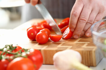 Knife slicing cherry tomato