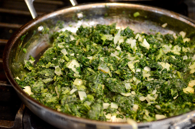 Spinach and onions cooking in a pan