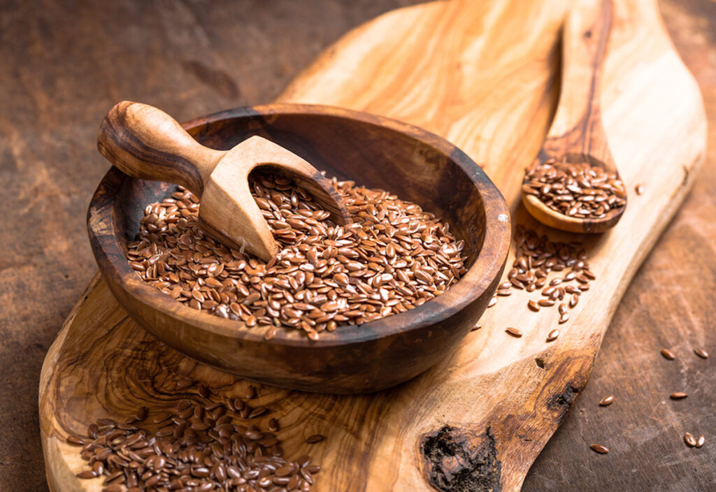 Flax Seeds In Bowl On Wooden Board