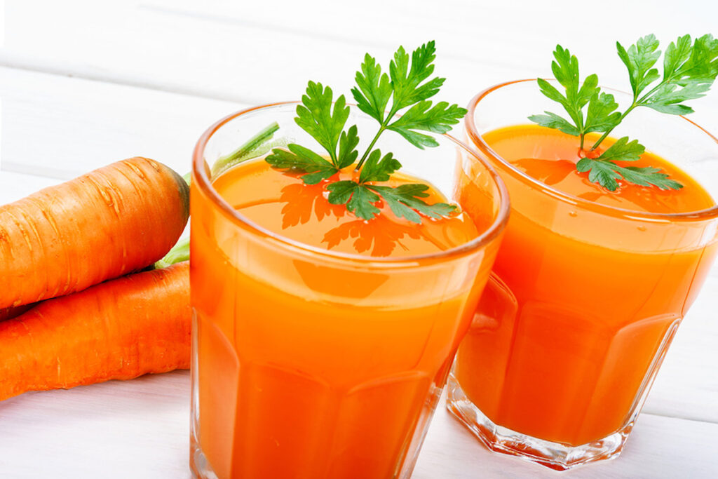 Carrot Juice in 2 glasses with 2 carrots