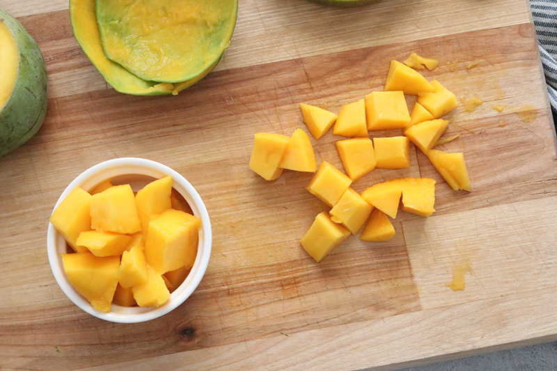 mango cut up into cubes on a cutting board
