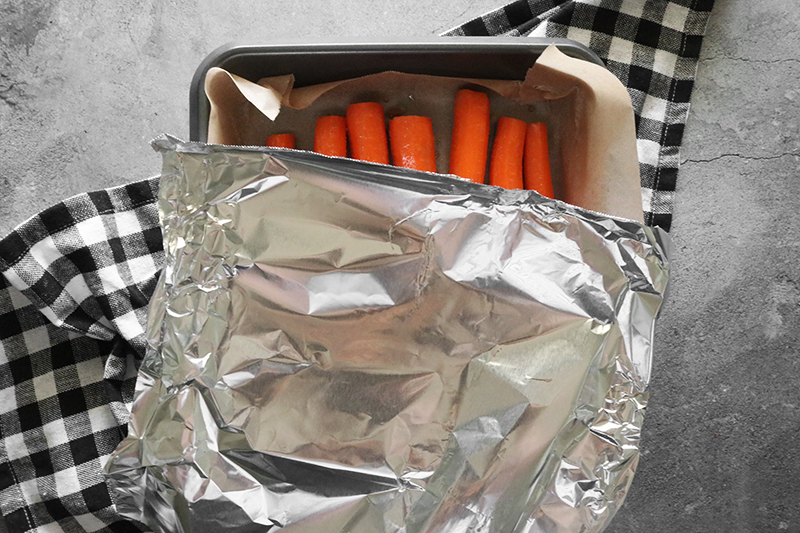 carrots in a pan covered with aluminum foil
