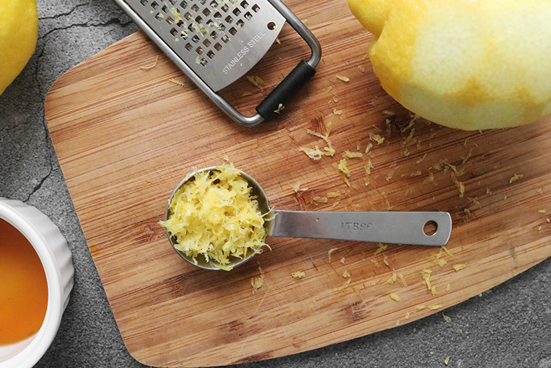 lemon zest in a tablespoon on a cutting board