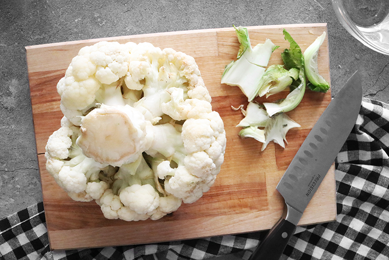 Cauliflower on a cutting board with a knife