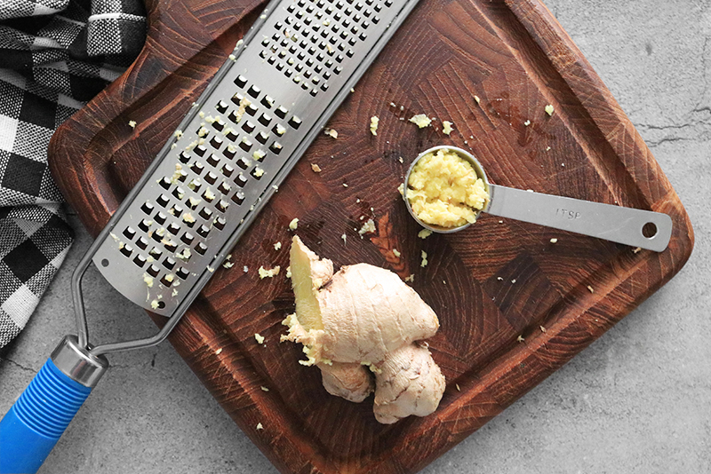 grated ginger on a cutting board in a tablespoon
