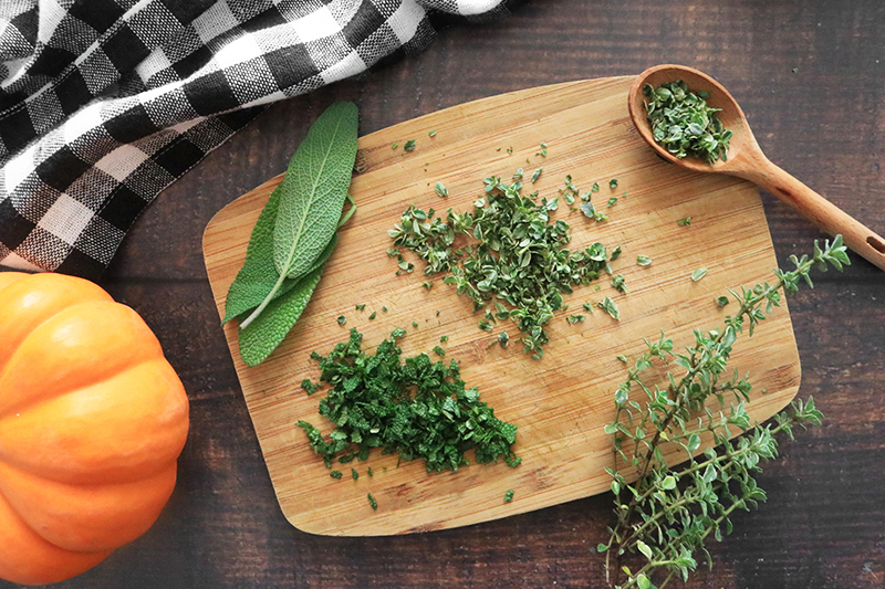 chopped sage and thyme on a cutting board