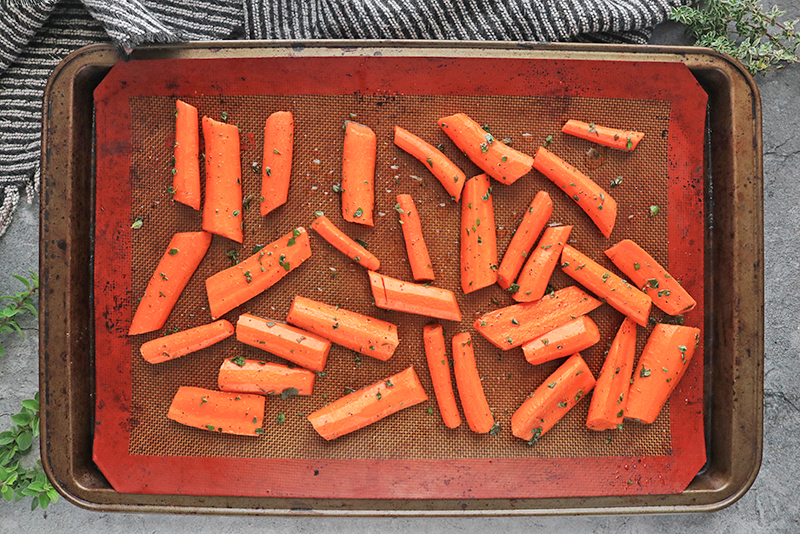 Glazed carrots on a silpat/baking sheet, ready for the oven.