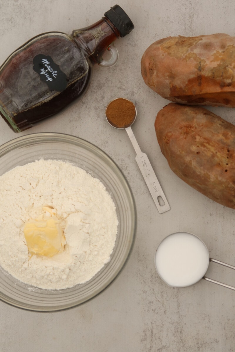 Vegan sweet potato pie ingredients including sweet potato, flour, vegan butter, spices, maple syrup, and milk.