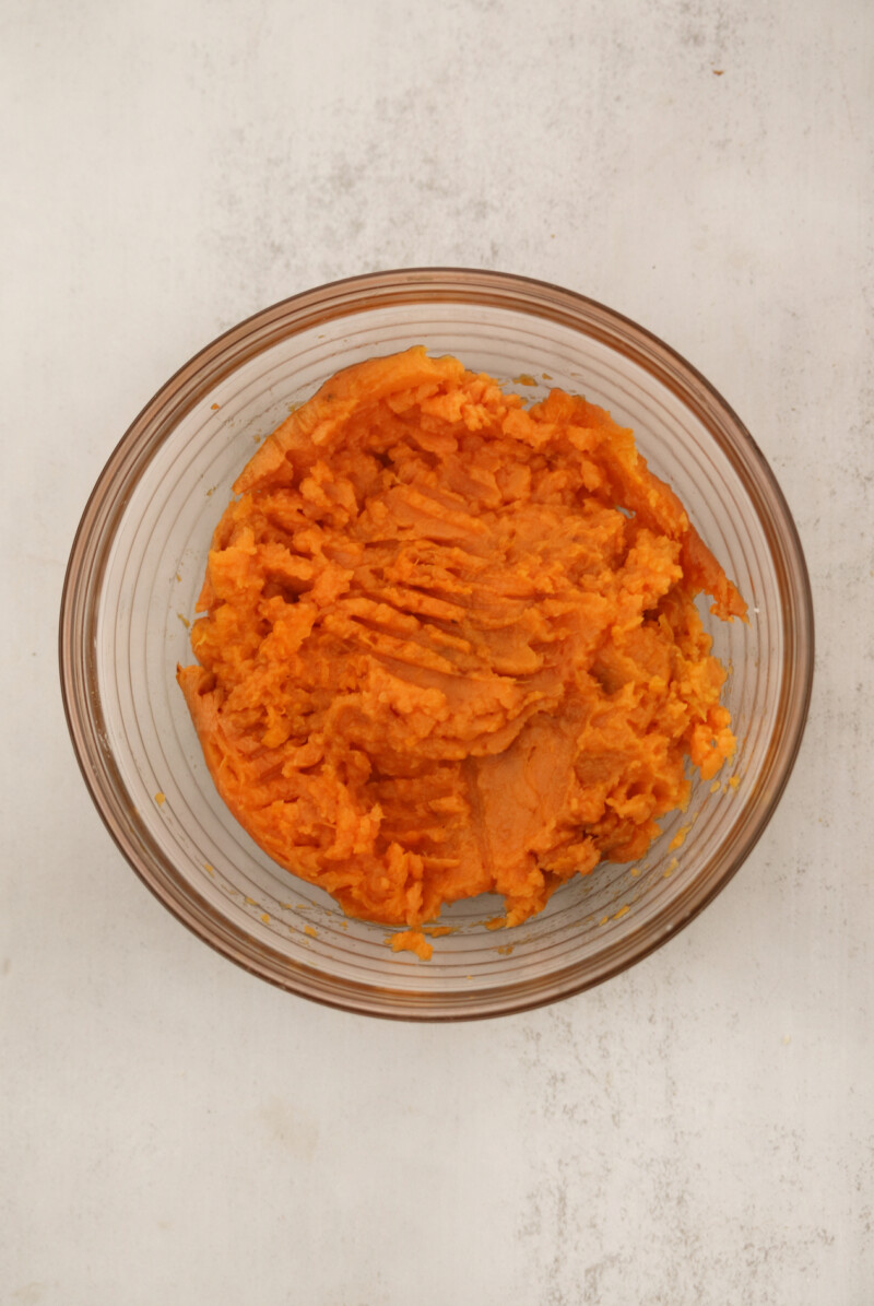 Sweet potatoes mashed in a glass bowl.