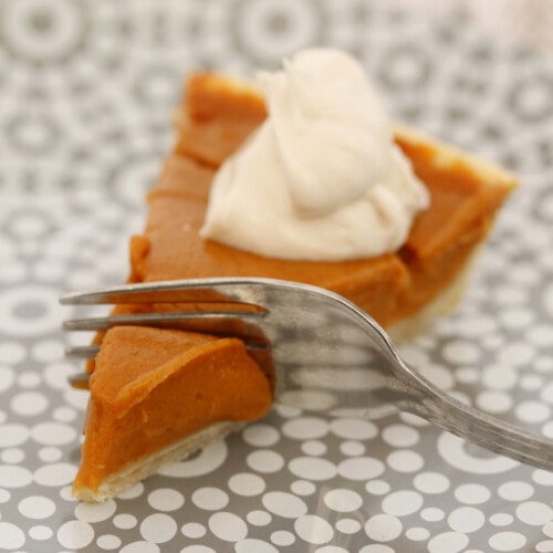 Close up shot of a single slice of vegan sweet potato pie with a fork slicing through it.