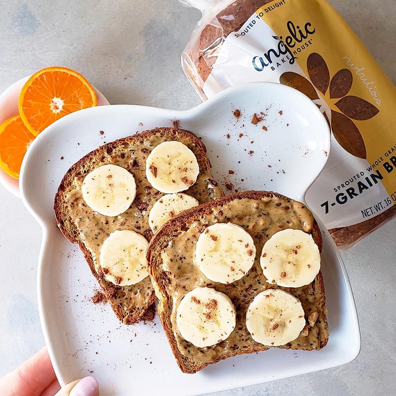 Peanut butter and banana toast, sprinkled with cinnamon, made out of Angelic Bakehouse Sprouted 7-Grain Bread.