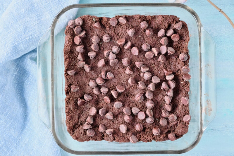 Vegan Avocado Brownies spread in a glass baking dish with chocolate chips.