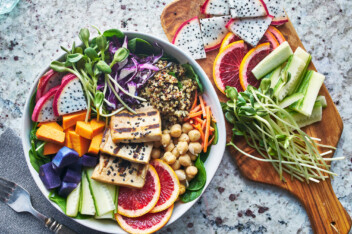 Vegan bowl with sprouts, dragon fruit, sweet potato, blood orange, tofu, chickpeas, and quinoa.
