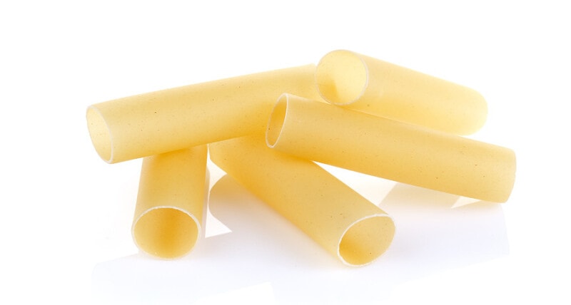 Close up of a of raw cannelloni pasta, a tubular pasta that is usually stuffed with meat or vegetables, on a white background.