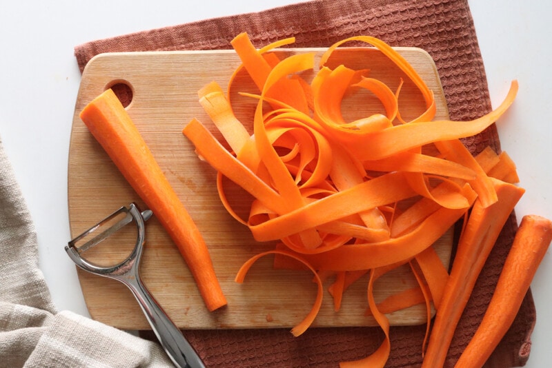 Peeling carrots into strips for vegan bacon