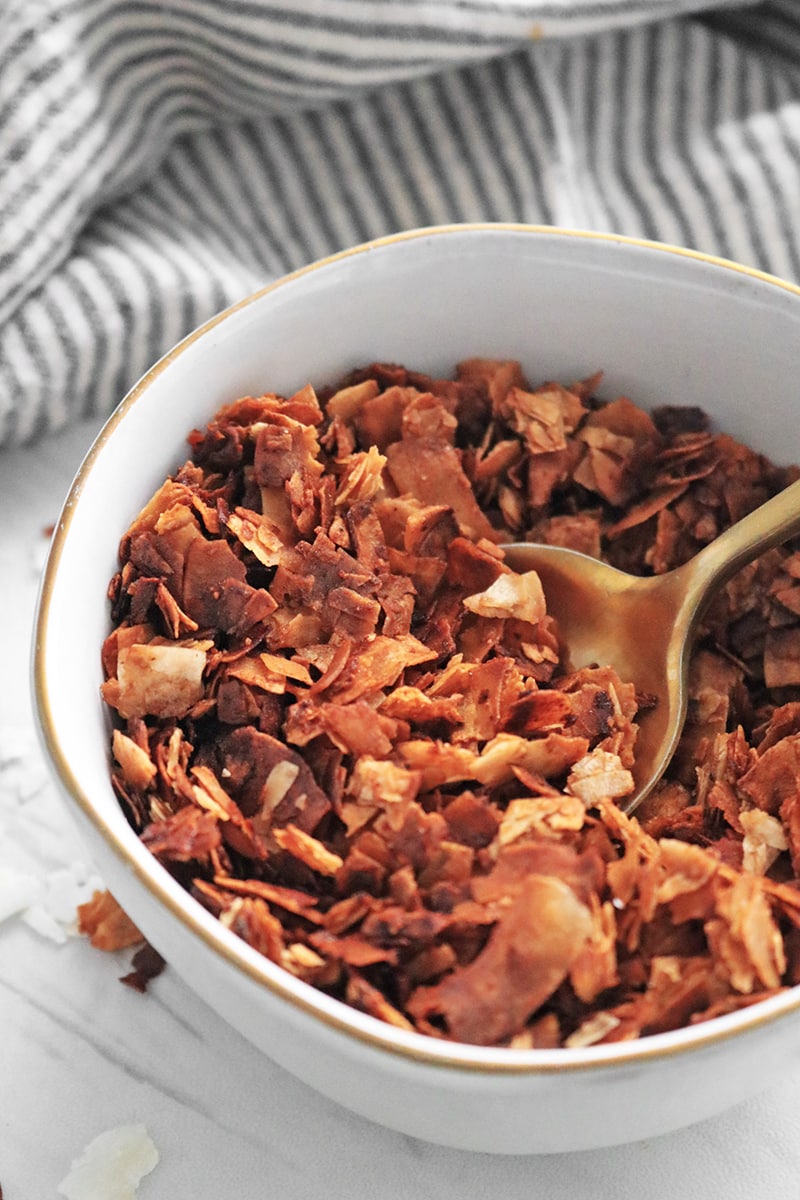 Close-up of coconut bacon in a bowl with a spoon