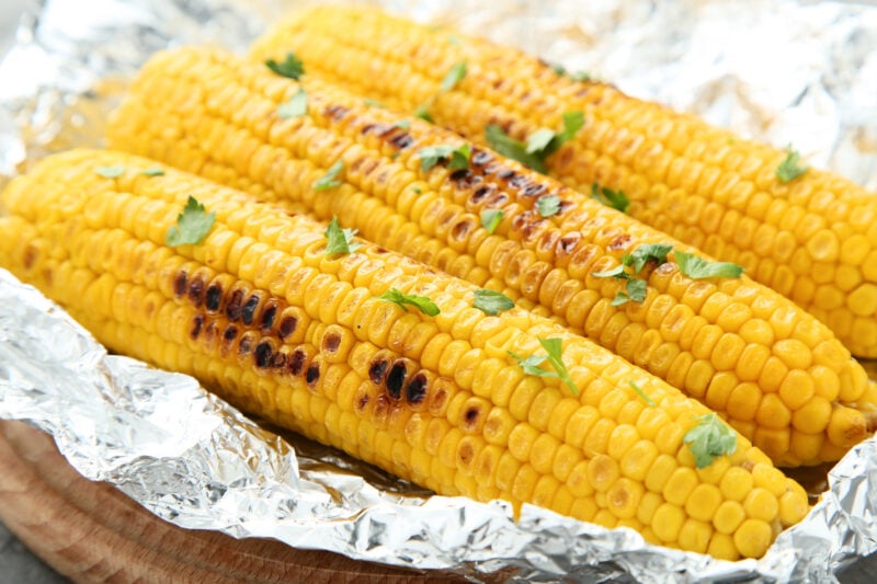 3 ears of corn wrapped in aluminum foil