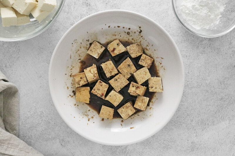 toss tofu cubes into marinade