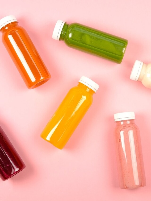 A variety of fresh juices and smoothies in glass bottles.
