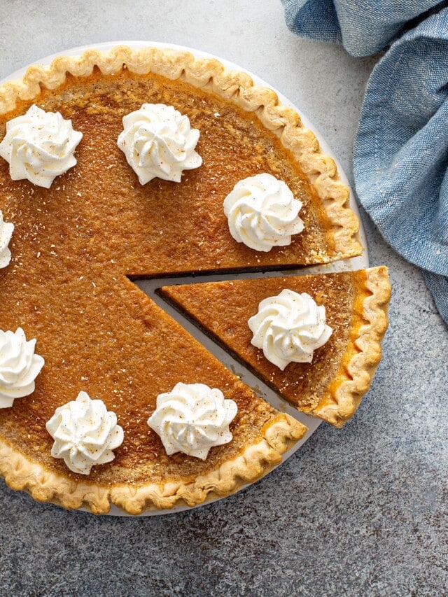 Vegan sweet potato pie, cut in slices, and topped with coconut whipped cream.