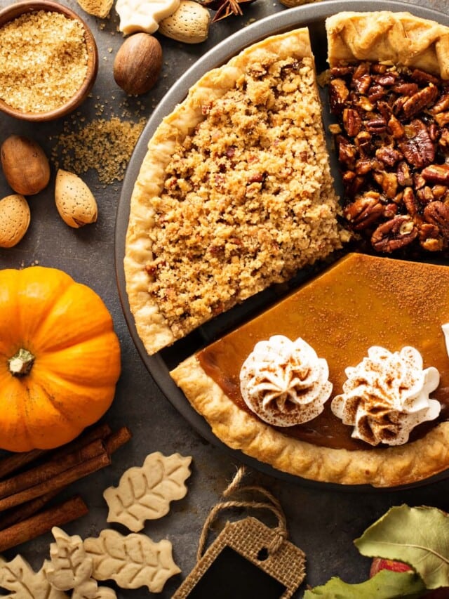 Thanksgiving traditional vegan pies pumpkin, pecan and apple crumble pie overhead shot