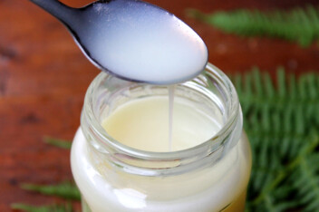Vegan Evaporated milk dripping off a spoon into a jar