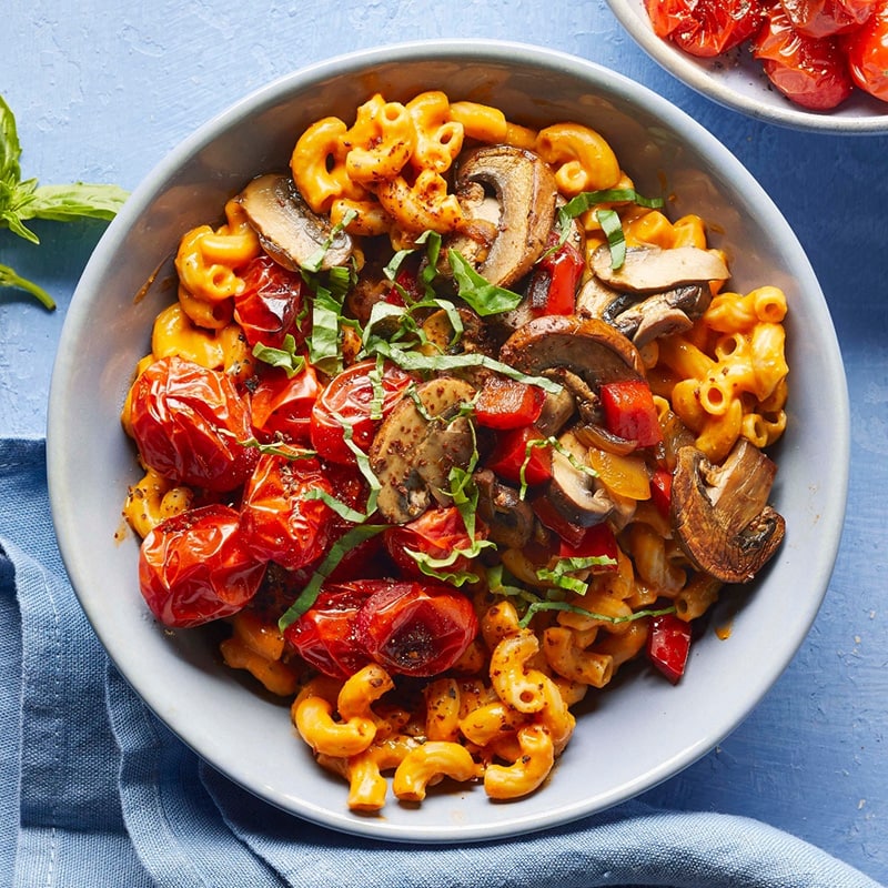 Vegan macaroni and cheese with fire roasted vegetables in a bowl.