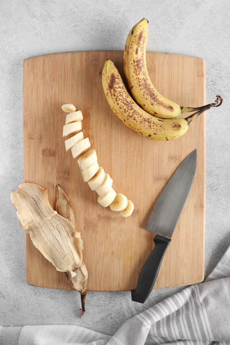 Banana sliced on a bamboo cutting board