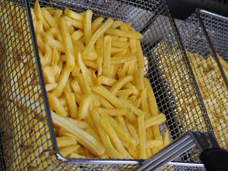 French fries being dropped in deep fryer