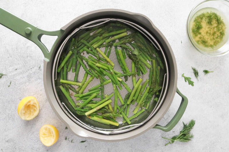 Blanching asparagus in a pot of water.