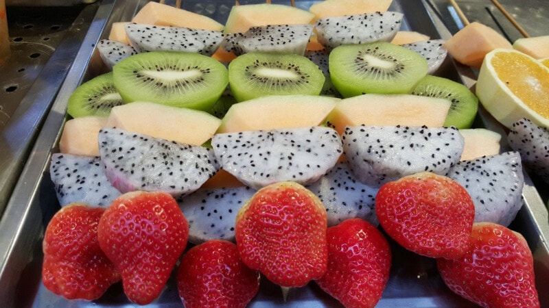 Fresh Tropical Fruit: Kiwi, Mango, Dragon Fruit, and Strawberry.