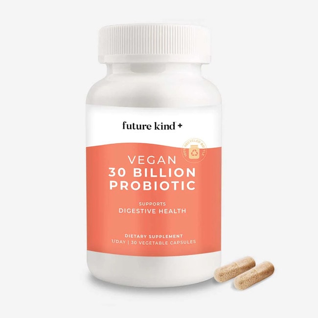 A white bottle with orange label of Future Kind+ Vegan Probiotic supplement containing 30 capsules, including two capsules on the outside of the bottle.