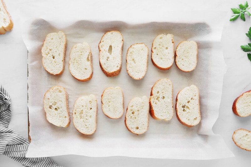 Sliced vegan garlic bread on a baking sheet.