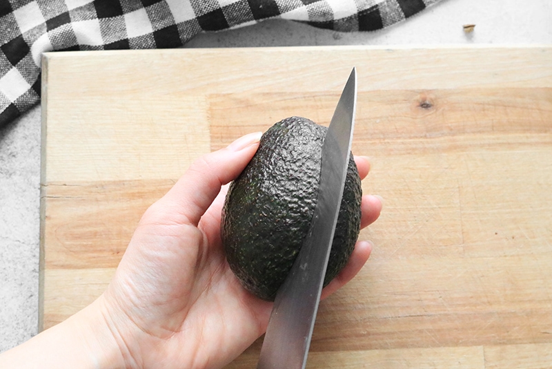 Cutting an avocado lengthwise, down the middle