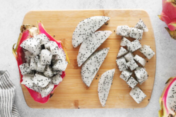 Diced and sliced dragon fruit on a cutting board.