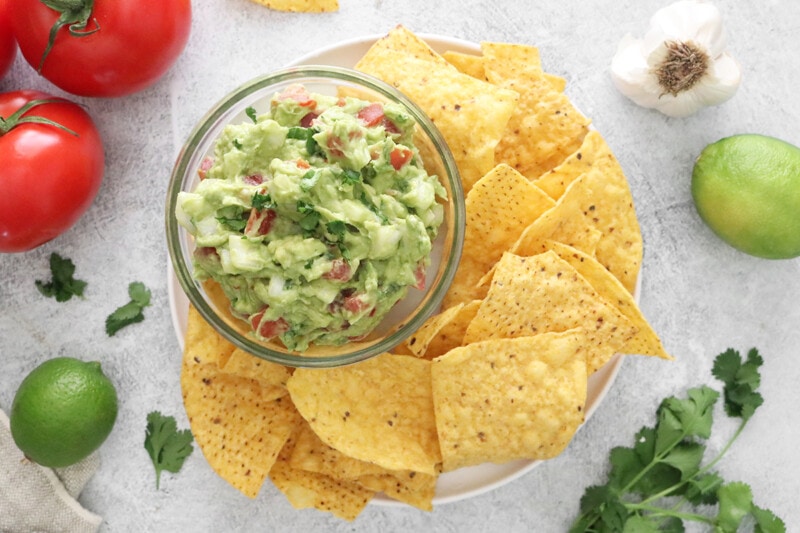 Guacamole in a bowl with tortilla chips.