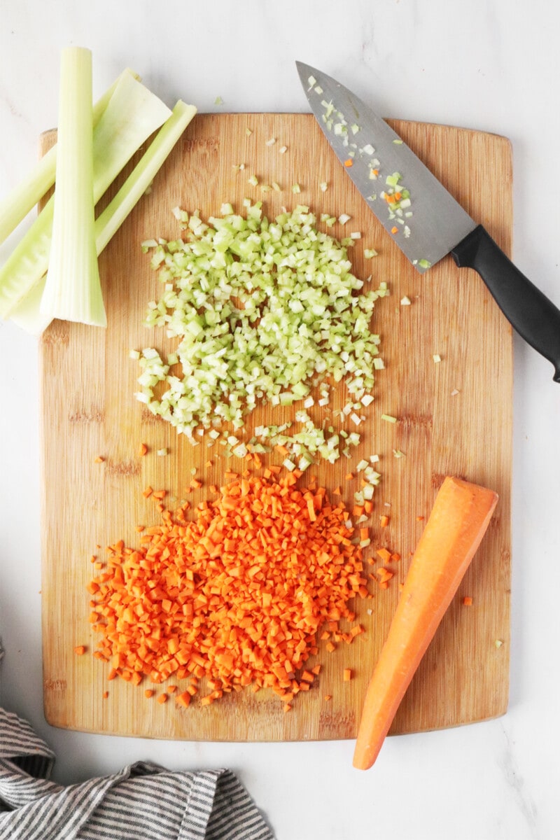 Minced celery and carrots on a cutting board.