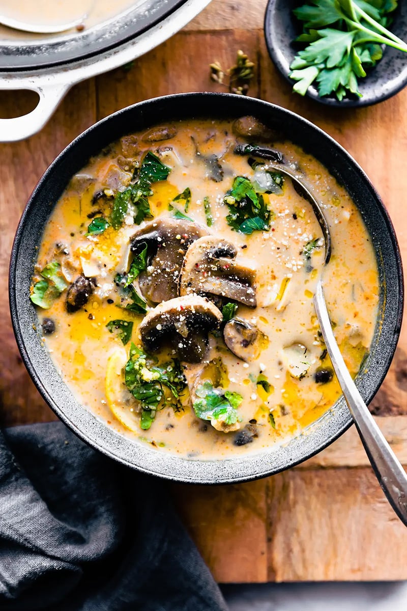 A bowl of creamy, Hungarian mushroom soup, topped with fresh herbs.