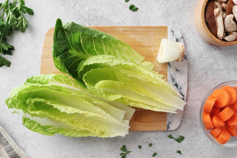 Lettuce leaves on a wooden cutting board.