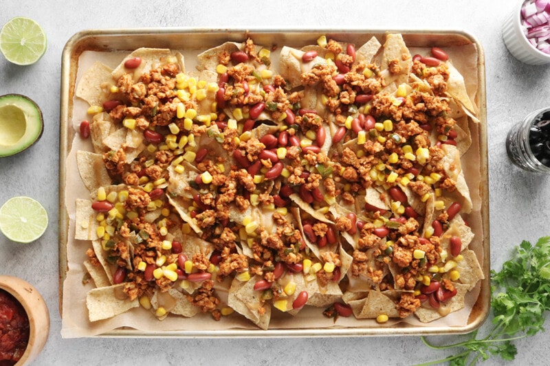 Loaded Vegan Nachos topped with kidney beans, corn, and tempeh