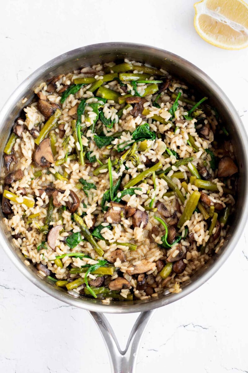 Mushroom and Asparagus Risotto with wilted spinach added to skillet.
