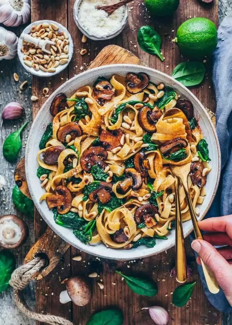 Vegan mushroom pasta with fresh spinach on a plate.
