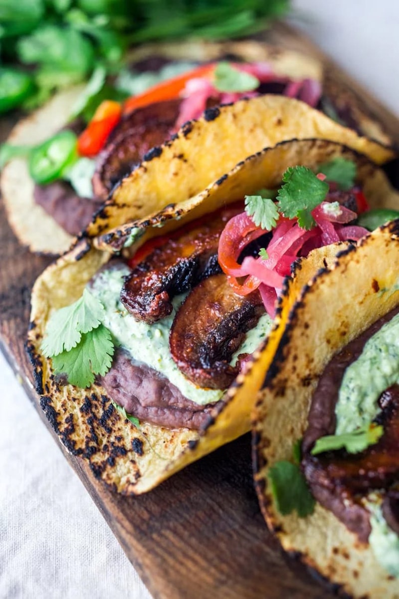 Chipotle portobello mushroom tacos in toasted corn tortillas, topped with fresh cilantro and pickled red onions.
