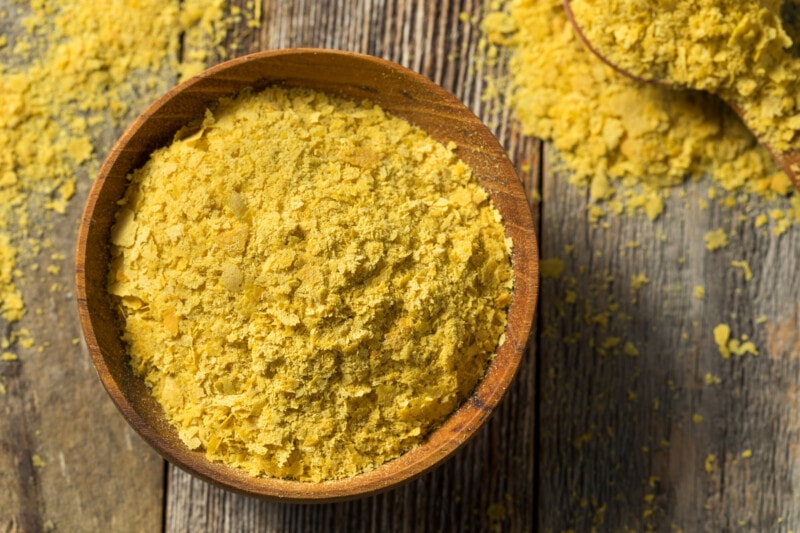 Nutritional yeast flakes in a wooden bowl.