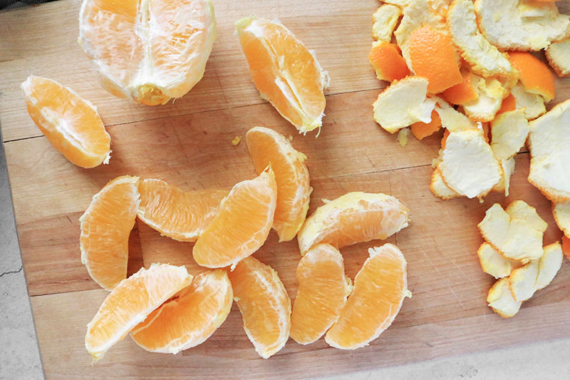 peeled and segmented oranges on a cutting board